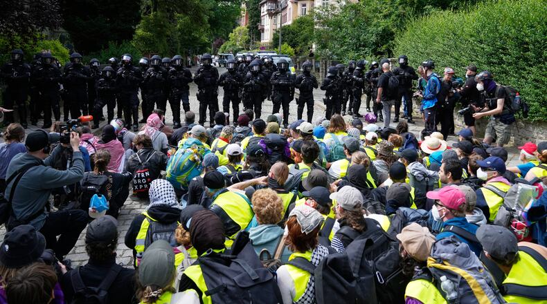Police officers guard as protesters block a road during a rally against party convention of Alternative for Germany, or AfD in Erfurt, Germany, Saturday, July 4, 2026. (AP Photo/Ebrahim Noroozi)
