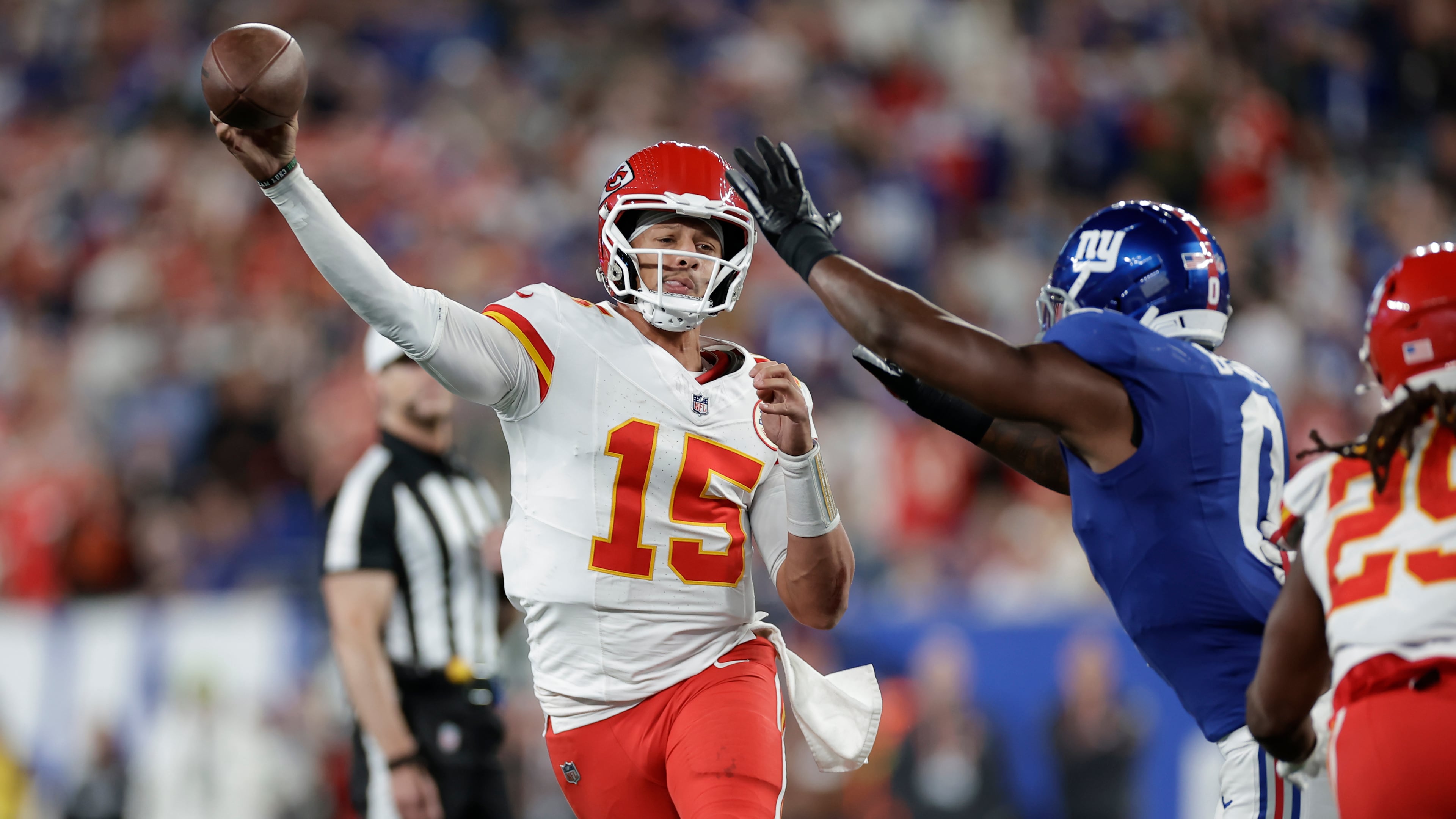 Kansas City Chiefs quarterback Patrick Mahomes (15) throws under pressure from New York Giants outside linebacker Brian Burns (0) during the first half of an NFL football game Sunday, Sept. 21, 2025, in East Rutherford, N.J. (AP Photo/Adam Hunger)