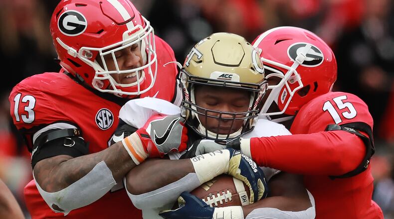 Georgia defensive end Jonathan Ledbetter and linebacker D'Andre Walker tackle Georgia Tech runner Jerry Howard during the first quarter in their NCAA college football rivalry game on Saturday, Nov. 24, 2018, in Athens. Curtis Compton/ccompton@ajc.com