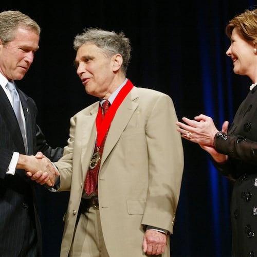 FILE - President Bush, left, shakes hands with Robert Coles, center, a child psychologist, researcher and professor of psychiatry from Cambridge, Mass., as first lady Laura Bush looks on during the National Endowment for the Arts Awards ceremony at Constitution Hall, April 22, 2002, in Washington. (AP Photo/Pablo Martinez Monsivais, File)
