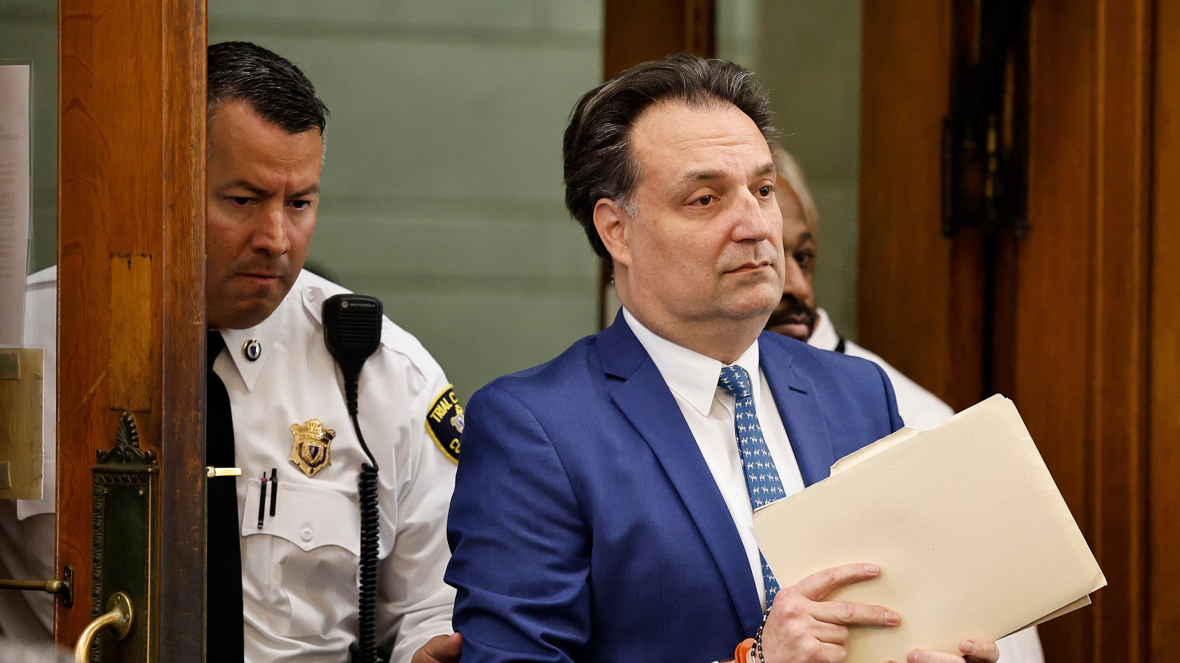 Brian Walshe enter the courtroom clutching papers and a rosary. Opening statements in the Brian Walshe murder trial in Norfolk Superior Court, Dedham, Mass., Monday, Dec. 1, 2025 (Greg Derr/The Patriot Ledger via AP, Pool)