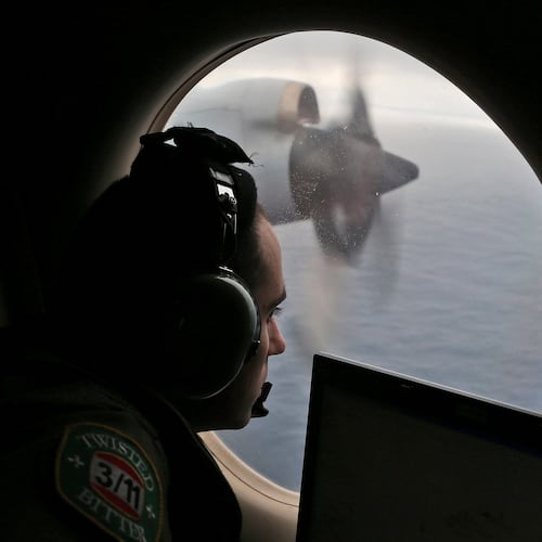 FILE - Flight officer Rayan Gharazeddine scans the water in the southern Indian Ocean off Australia from a Royal Australian Air Force AP-3C Orion during a search for the missing Malaysia Airlines Flight MH370 on March 22, 2014. (AP Photo/Rob Griffith, File)wld