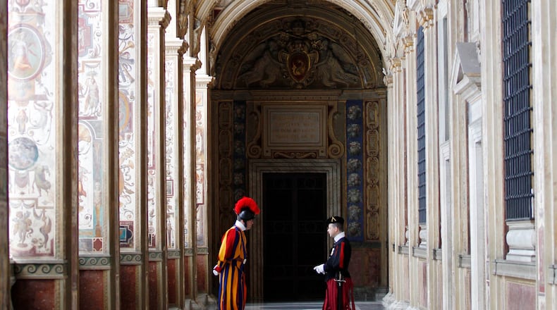 FILE - Swiss guards talk in a Vatican corridor prior to a private audience of Pope Francis to the Archbishop of Canterbury Justin Welby, at the Vatican Friday, June 14, 2013. (AP Photo/Alessandra Tarantino, file)
