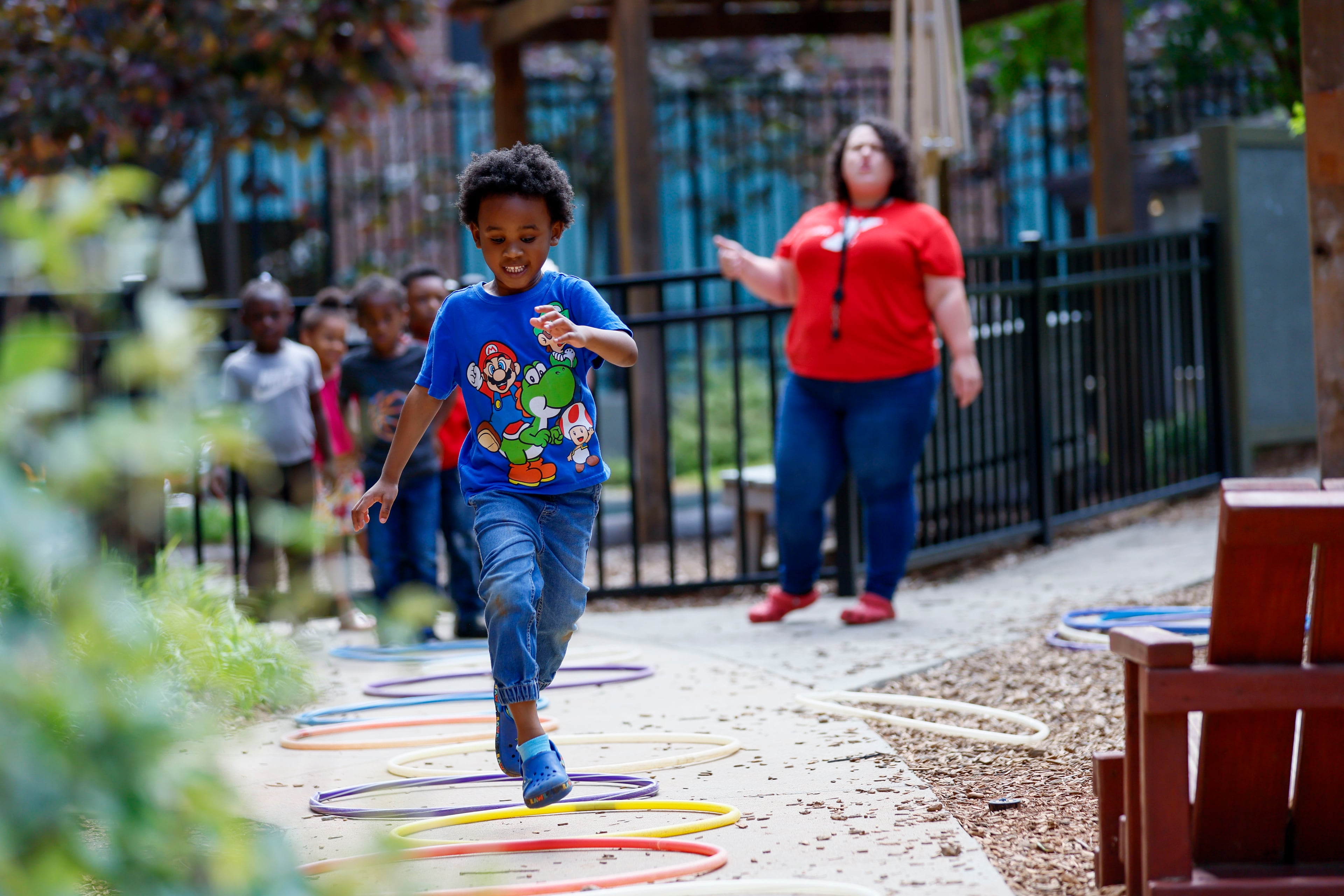 A child in the Head Start program plays outside with lead teacher Genesis Lavanway at the Arthur M. Blank Early Learning Center, Monday. (Miguel Martinez/AJC)