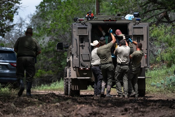 Texas Department of Public Safety Troopers load a recovered body into the back of a vehicle for transport near the Guadalupe River after a flash flood swept through the area, Monday, July 7, 2025, in Ingram, Texas. (AP Photo/Eli Hartman)