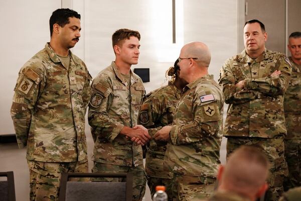 U.S. Army Command Sgt. Maj. Thomas Delano, command sergeant major, Joint Task Force-District of Columbia, awards his coin to Airman 1st Class Jacob Decker, a National Guardsman with the Georgia National Guard, assigned to JTF-DC of Columbia, in support of the DC Safe and Beautiful mission, in Arlington, Virginia, Aug. 19, 2026. (Courtesy of Staff Sgt. Adrianne Lopez/U.S. Army National Guard)