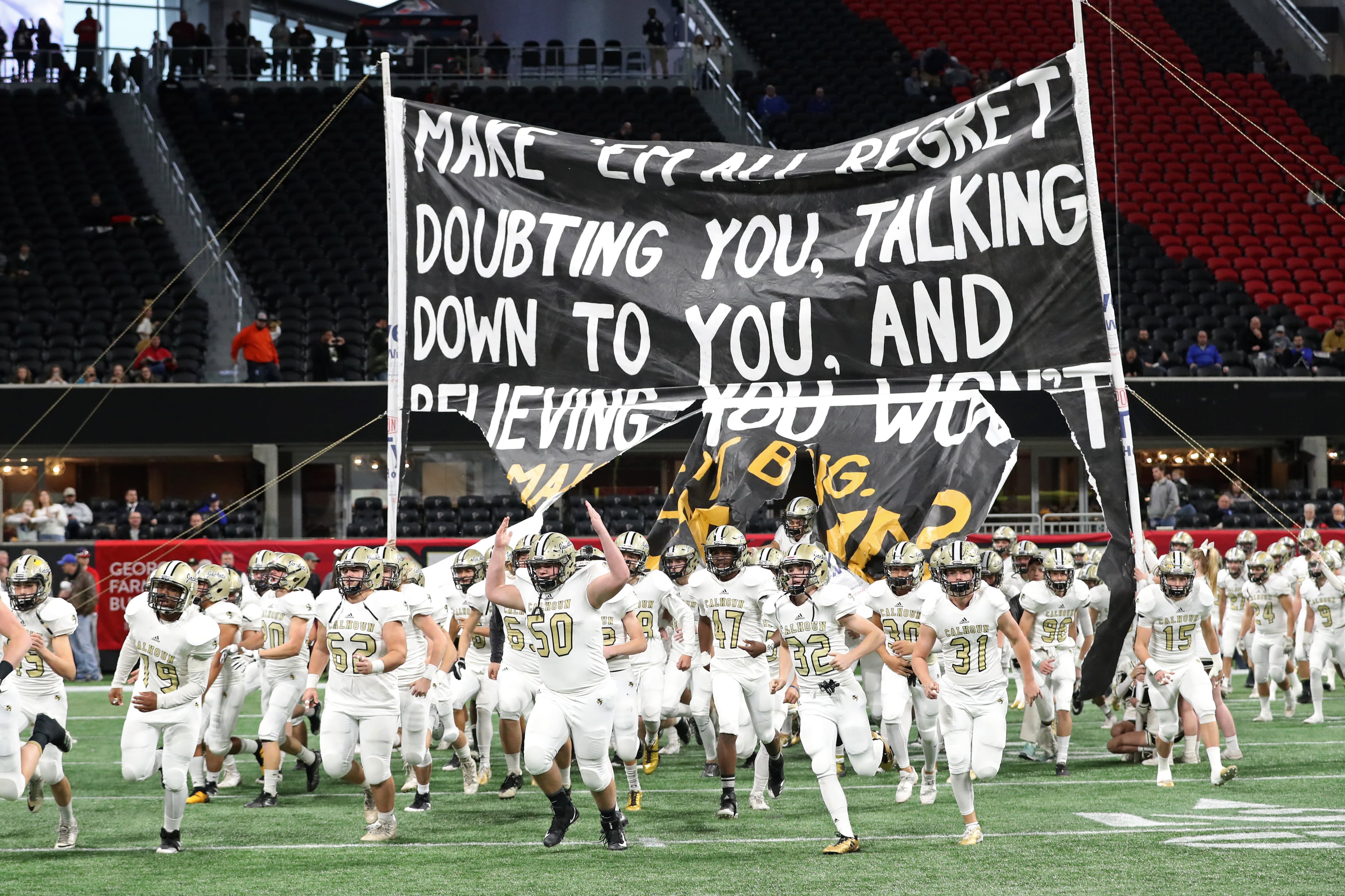 Calhoun players run onto the field before their game against Peach County during the Class AAA Championship at Mercedes-Benz Stadium Friday, December 8, 2017, in Atlanta.