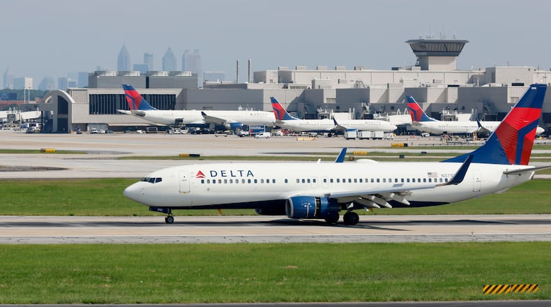 With the Atlanta skyline in the background, a Delta airplane lands at Hartsfield-Jackson International Airport on Sept. 7, 2022, in Atlanta. (Jason Getz/The Atlanta Journal-Constitution/TNS)