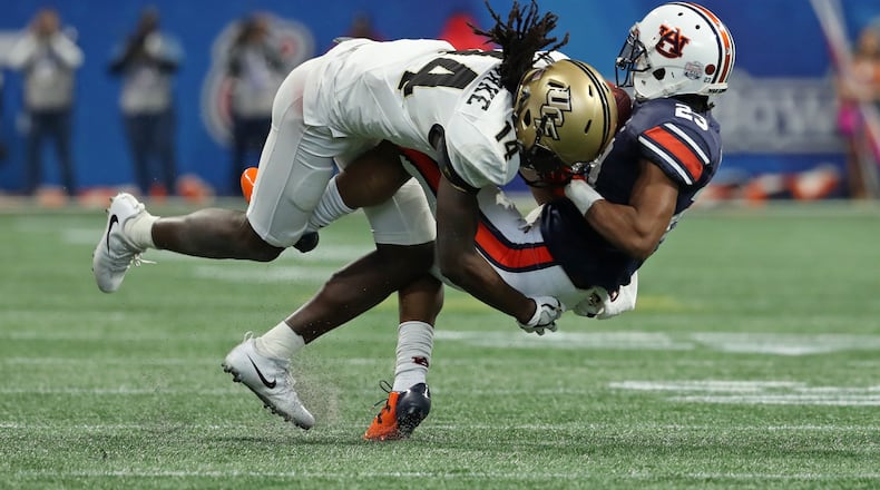 January 1, 2018 - Atlanta, Ga: UCF Knights defensive back Nevelle Clarke (14) tackles Auburn Tigers wide receiver Ryan Davis (23) after a catch by Davis during the second quarter of the Chick-fil-A Peach Bowl at Mercedes-Benz Stadium Monday, January 1, 2018, in Atlanta. PHOTO / JASON GETZ