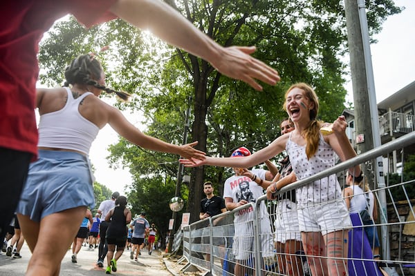 An audience interacts with race participants during the 55th Peachtree Road Race in Atlanta on Thursday, July 4, 2024.  (Ziyu Julian Zhu / AJC)