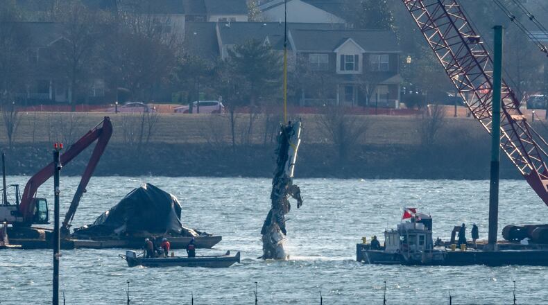FILE - A piece of wreckage is lifted from the water onto a salvage vessel near the site in the Potomac River of a mid-air collision between an American Airlines jet and a Black Hawk helicopter, at Ronald Reagan Washington National Airport, Feb. 4, 2025, in Arlington, Va. (AP Photo/Ben Curtis, File)