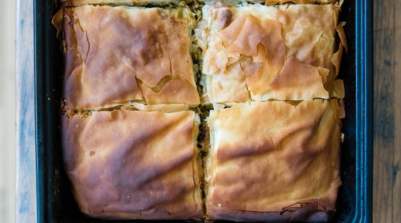 A pan full of spanakopita, the Greek phyllo pie made with a Southern twist: collard greens and kale have been substituted for the spinach. CONTRIBUTED BY HENRI HOLLIS