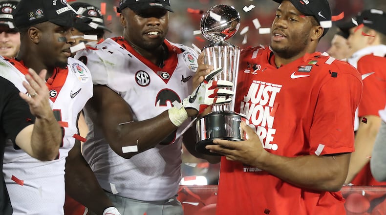 Sony Michel, Roquan Smith and Nick Chubb share the Rose Bowl trophy after beating Oklahoma 54-48 in a College Football Playoff Semifinal  on Monday.