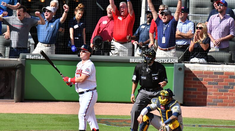 Happy times at Truist Park: Fans react as Joc Pederson follows through on his three-run pinch hit home run that provided all of the scoring in Monday's 3-0 victory over the Brewers.