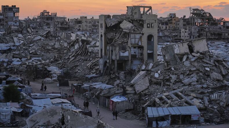 Palestinians walk amid war-damaged buildings in Gaza City, Wednesday, Sept. 23, 2026. (AP Photo/Jehad Alshrafi)
