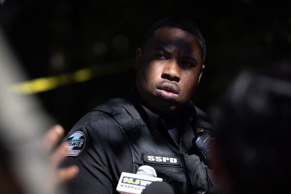 Sandy Springs police officer Jarrell Greene speaks to reporters at the scene Tuesday. (Arvin Temkar/AJC)