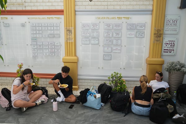 Evacuees from Israel eat food at a Jews community center after they arrived from Israel with a ship, at the port of Larnaca, Cyprus, Wednesday, June 18, 2025. (AP Photo/Petros Karadjias)