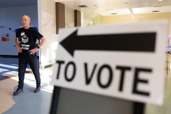 Poll worker Patrick Cox waits for voters at the Johns Creek Environmental Campus in Alpharetta. (Ben Gray for the AJC)