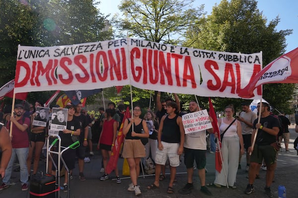 People ask for the resignation of Milan's Mayor Giuseppe Sala outside the City Council Monday, July 21, 2025, in Milan, northern Italy, as prosecutors are investigating more than 70 individuals, including Mayor Sala, over a sprawling corruption probe into the city's real estate industry. (AP Photo/Antonio Calanni)