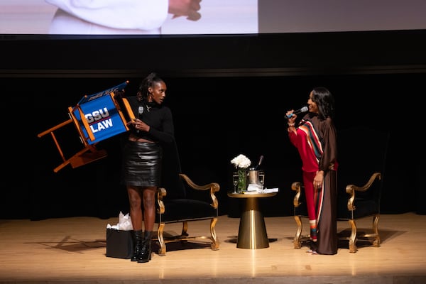 Actress and writer Issa Rae (left) holds a gift chair after speaking with Georgia State law professor Mo Ivory at Rialto Center for the Arts in Atlanta. The Rialto Club is celebrating 30 years.  (Arvin Temkar/AJC 2024)