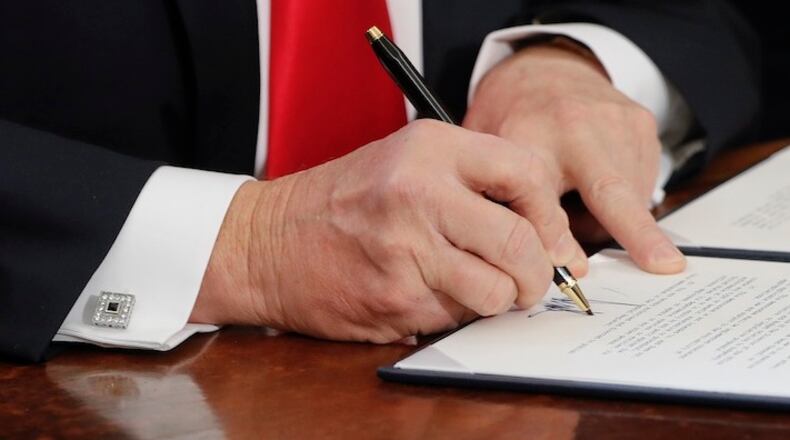 President Donald Trump signs an executive order in the Oval Office of the White House in Washington, Friday, Feb. 3, 2017. (AP Photo/Pablo Martinez Monsivais)
