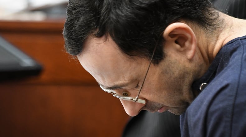 Larry Nassar hangs his head as a former gymnast details how he abused her.  For decades after victims first told state employees of his abuse, a code of silence protected the physician as he went on to sexually violate some 250 girls and women. Some states are now considering measures to prevent such predators.  (Matthew Dae Smith/Lansing State Journal via AP)