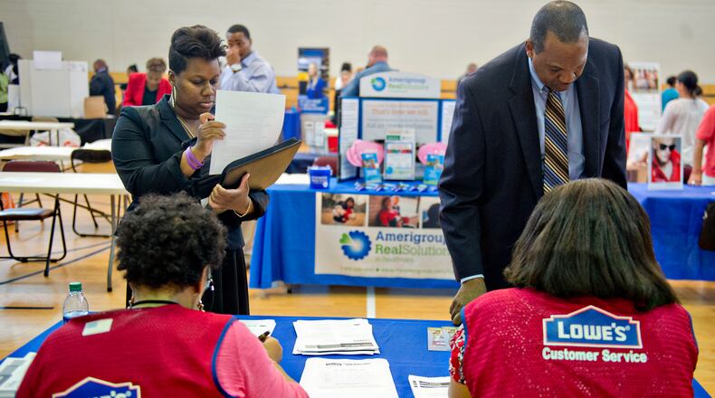 Krystal Flott (left) and Alan Harmon speak with Carolyn Beasley and Tracey Scott from Lowe's as they attend the South Clayton Job Fair at the South Clayton Recreation Center in Hampton on Sept. 30.