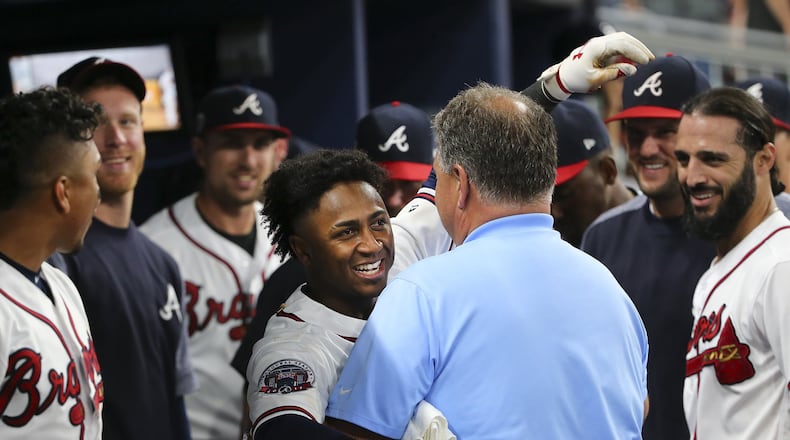 Atlanta Braves rookie second baseman Ozzie Albies embraces trainer Jim Lovell after hitting a three-run home run during the ninth inning of the team’s baseball game against the Los Angeles Dodgers on Thursday, Aug. 3, 2017, in Atlanta. The Dodgers won 7-4. The homer is Albies’ first hit in the majors. (AP Photo/John Bazemore)