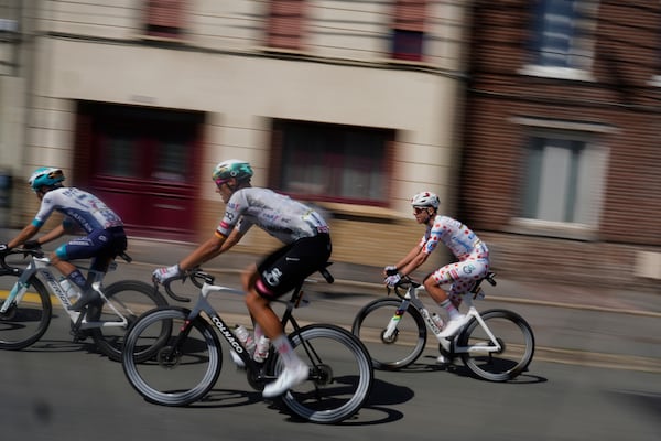 Slovenia's Tadej Pogacar wearing the best climber's dotted jersey, right, rides with Germany's Nils Politt, center, and France's Lenny Martinez during the third stage of the Tour de France cycling race over 178.3 kilometers (110.8 miles) with start in Valenciennes and finish in Dunkerque, France, Monday, July 7, 2025. (AP Photo/Mosa'ab Elshamy)