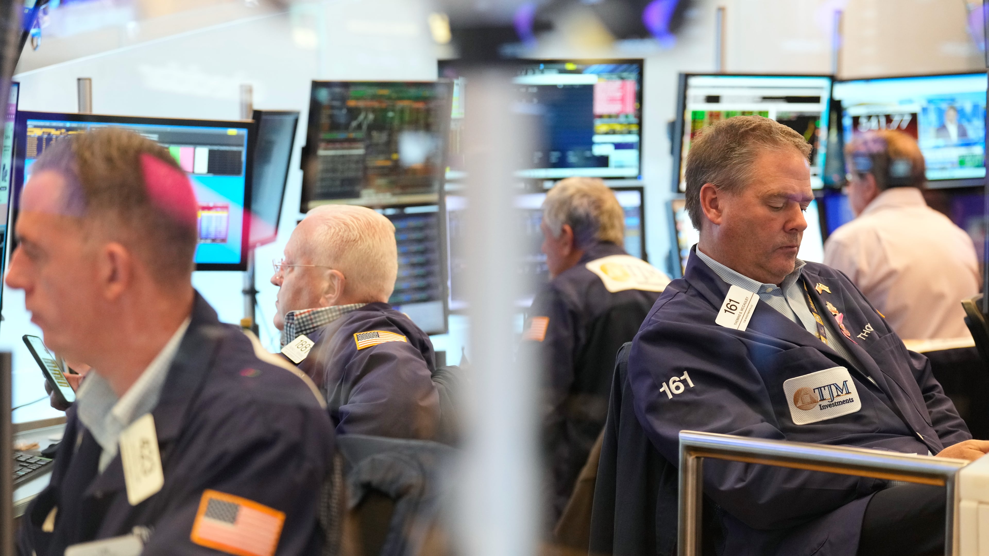 Traders, including Thomas McCauley, second from right, work on the floor at the New York Stock Exchange in New York, Wednesday, Oct. 29, 2025. (AP Photo/Seth Wenig)