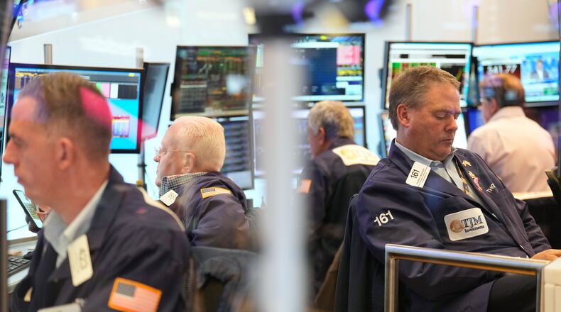 Traders, including Thomas McCauley, second from right, work on the floor at the New York Stock Exchange in New York, Wednesday, Oct. 29, 2025. (AP Photo/Seth Wenig)