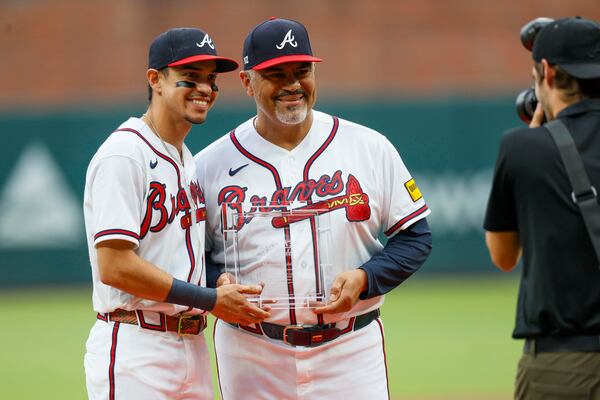 Braves left fielder Mauricio Dubón (left) is joined by coach Eddie Pérez as he receives the Heart and Hustle Award on Wednesday. (Miguel Martinez/AJC)