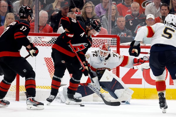 Carolina Hurricanes' Sebastian Aho (20) redirects the puck past Florida Panthers goaltender Sergei Bobrovsky (72) with Andrei Svechnikov (37) nearby during the first period of Game 1 of the NHL hockey Stanley Cup Eastern Conference finals in Raleigh, N.C., Tuesday, May 20, 2025. (AP Photo/Karl DeBlaker)