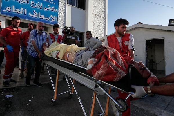 Syrian Red Crescent volunteers carry a man who was injured during clashes between Sunni Bedouin clans and Druze militias, at Ezraa hospital, southern Syria, Monday, July 14, 2025. (AP Photo/Omar Sanadiki)