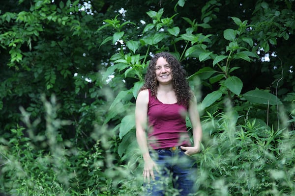 Amanda Beltranmini Healen stands among the plants in her backyard in Nashville, Tenn., Monday, May 19, 2025, where she participates in No Mow Months to improve water retention and encourage pollinators. (AP Photo/Kristin M. Hall)