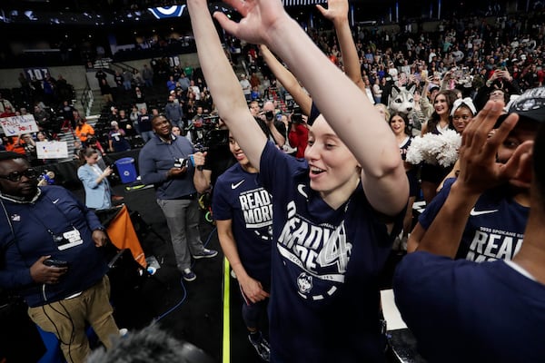 UConn guard Paige Bueckers, center, and her teammates celebrate with the school band and cheerleaders after the team's win against Southern California in the Elite Eight of the NCAA college basketball tournament, Monday, March 31, 2025, in Spokane, Wash. (AP Photo/Young Kwak)
