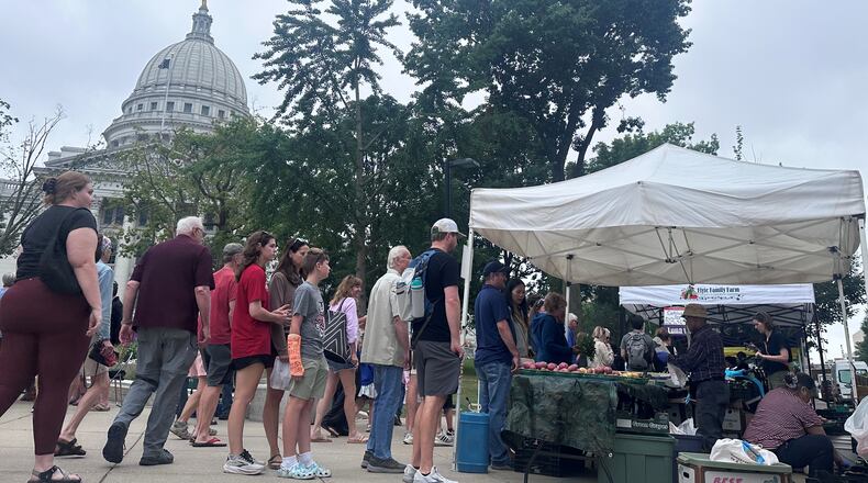 Shoppers line up at the farmers market outside of the Wisconsin state Capitol on Saturday, July 26, 2026, in Madison, Wis. (AP Photo/Scott Bauer)