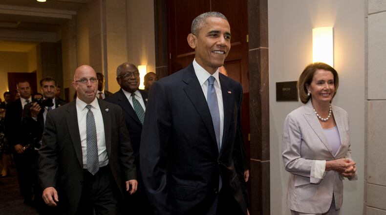 President Barack Obama walks with House Minority Leader Nancy Pelosi of Calif., right and House Minority Assistant Leader James Clyburn of S.C., as he visits Capitol Hill in Washington on Friday for a meeting with House Democrats. The president made an 11th-hour appeal to dubious Democrats on Friday in a tense run-up to a House showdown on legislation to strengthen his hand in global trade talks (AP/Carolyn Kaster)