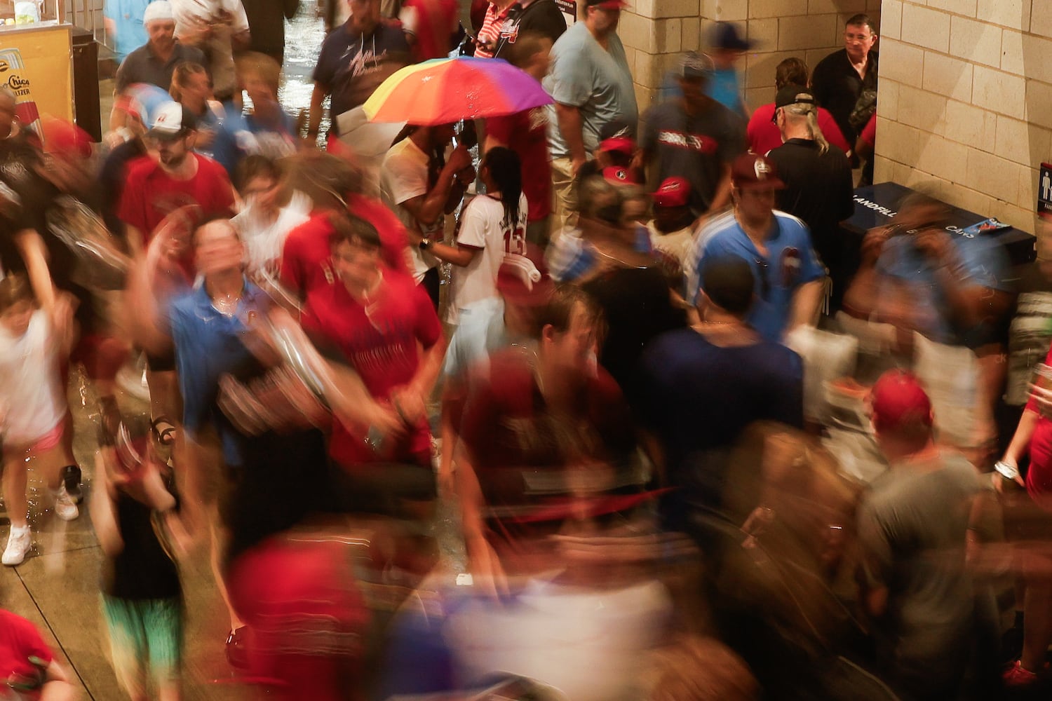 Fans wait under cover during a rain delay before the first inning of the Braves versus Philadelphia Phillies game at Truist Park in Atlanta on Friday, June 27, 2025. (Abbey Cutrer / AJC)