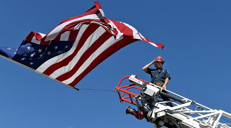 A captain with the Clifton Fire Protection District salutes the passing procession carrying the bodies of three firefighters killed while fighting the Snyder Fire in Grand Junction, Colo. Sunday, June 28, 2026. (Gretel Daugherty via AP)