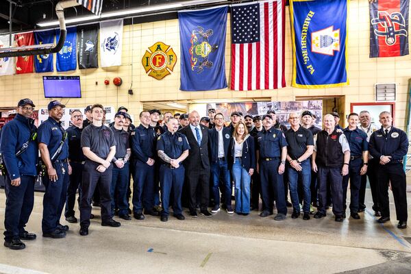 Pennsylvania Gov. Josh Shapiro and first lady Lori Shapiro, in center, pose for a photo with firefighters, Thursday, April 17, 2025, thanking them for their efforts after Sunday's arson attack at the Governor's Residence. (Dan Gleiter/The Patriot-News via AP)