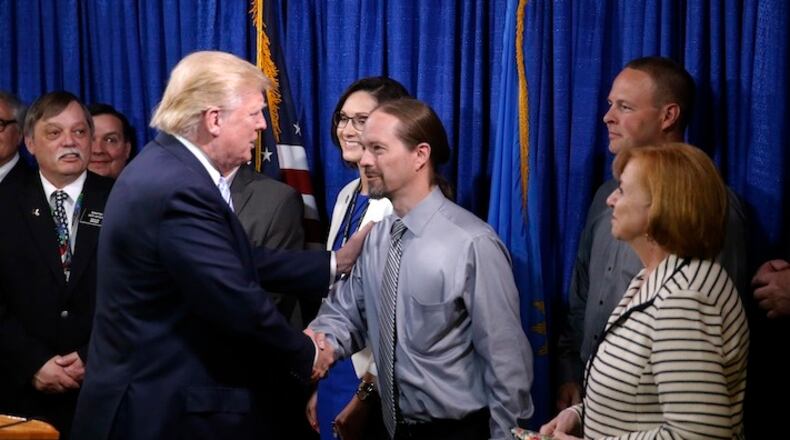 Republican presidential candidate Donald Trump, right, shakes the hand of John Trandem one of the 22 delegates from North Dakota to the Republican National Convention, who are the core of delegates that elevated Trump over the 1237 needed for the GOP's presidential nomination, Thursday, May 26, 2016, in Bismarck, N.D. (AP Photo/Charles Rex Arbogast)