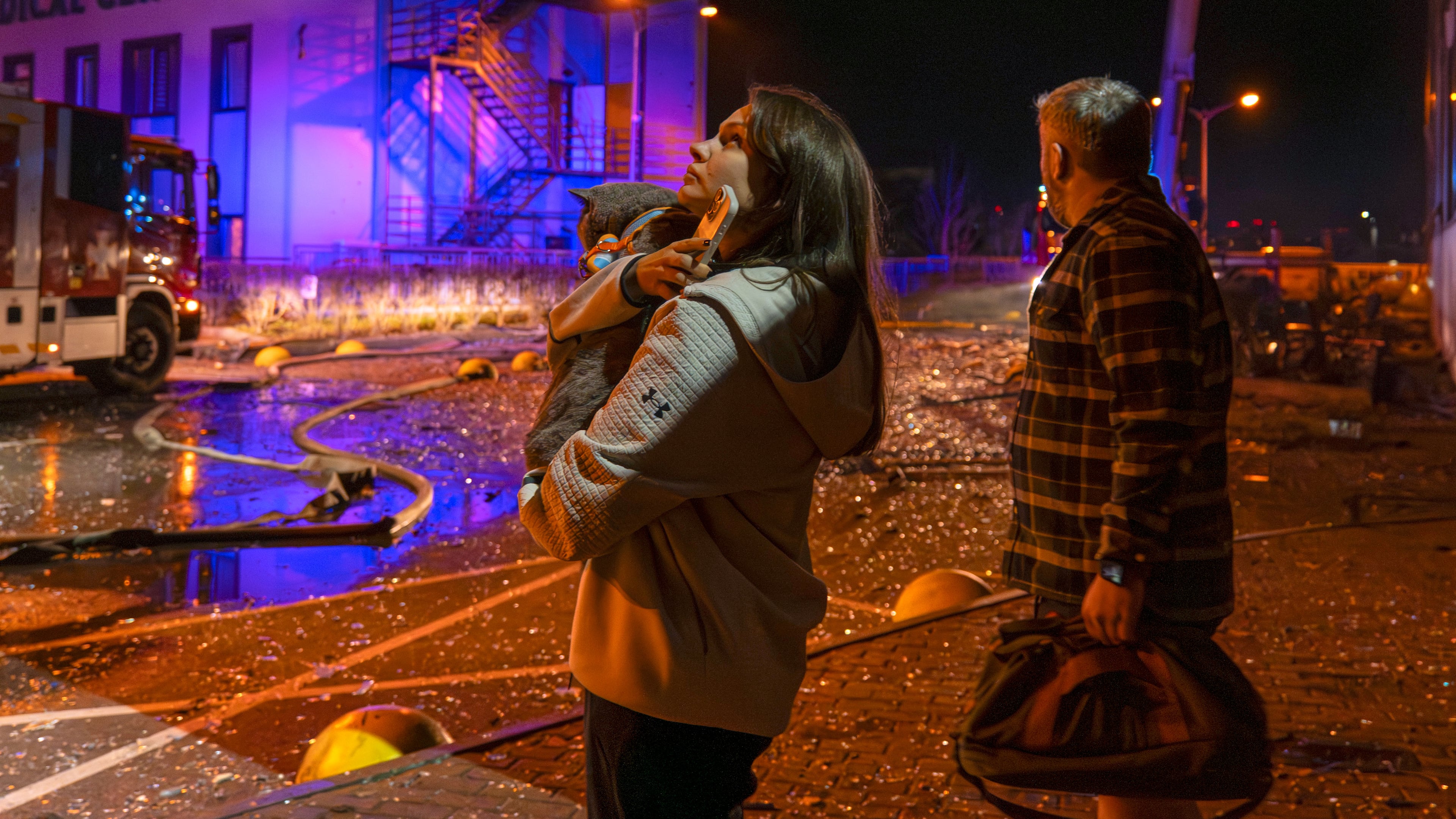 People watch as emergency services personnel work to extinguish a fire following a Russian attack in Kyiv, Ukraine, Tuesday, Nov. 25, 2025. (AP Photo/Dan Bashakov)