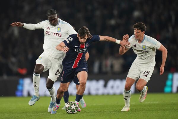 PSG's Khvicha Kvaratskhelia, centre, challenges for the ball with Aston Villa's Amadou Onana, left, and Aston Villa's Pau Torres, right, during the Champions League quarterfinal first leg soccer match between Paris Saint-Germain and Aston Villa at Parc des Princes stadium in Paris, Wednesday, April 9, 2025. (AP Photo/Thibault Camus)