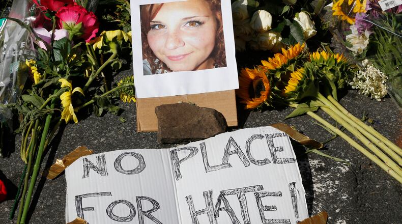 A makeshift memorial of flowers and a photo of victim, Heather Heyer, sits in Charlottesville, Va., Sunday, Aug. 13, 2017. Heyer died when a car rammed into a group of people who were protesting the presence of white supremacists who had gathered in the city for a rally. (AP Photo/Steve Helber)