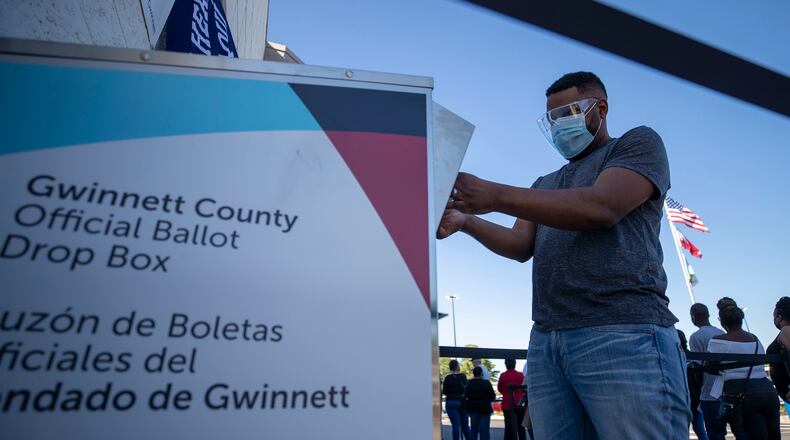 A Gwinnett County voter places his mail-in ballot inside an official drop box. In two Gwinnett school board districts, voters will select their representatives on May 24. (Alyssa Pointer/Atlanta Journal-Constitution/TNS)