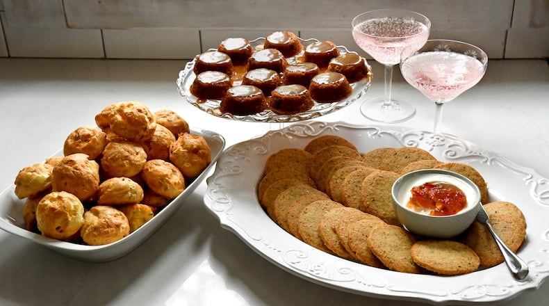 Bake your way into your holiday guests' good graces with Gougeres (left), Sticky Toffee Pudding Bites (upper center) and Cheddar Black Pepper Sables (right). (Styling by Ashley Thomas and Morgan Perkins / Chris Hunt for the AJC)