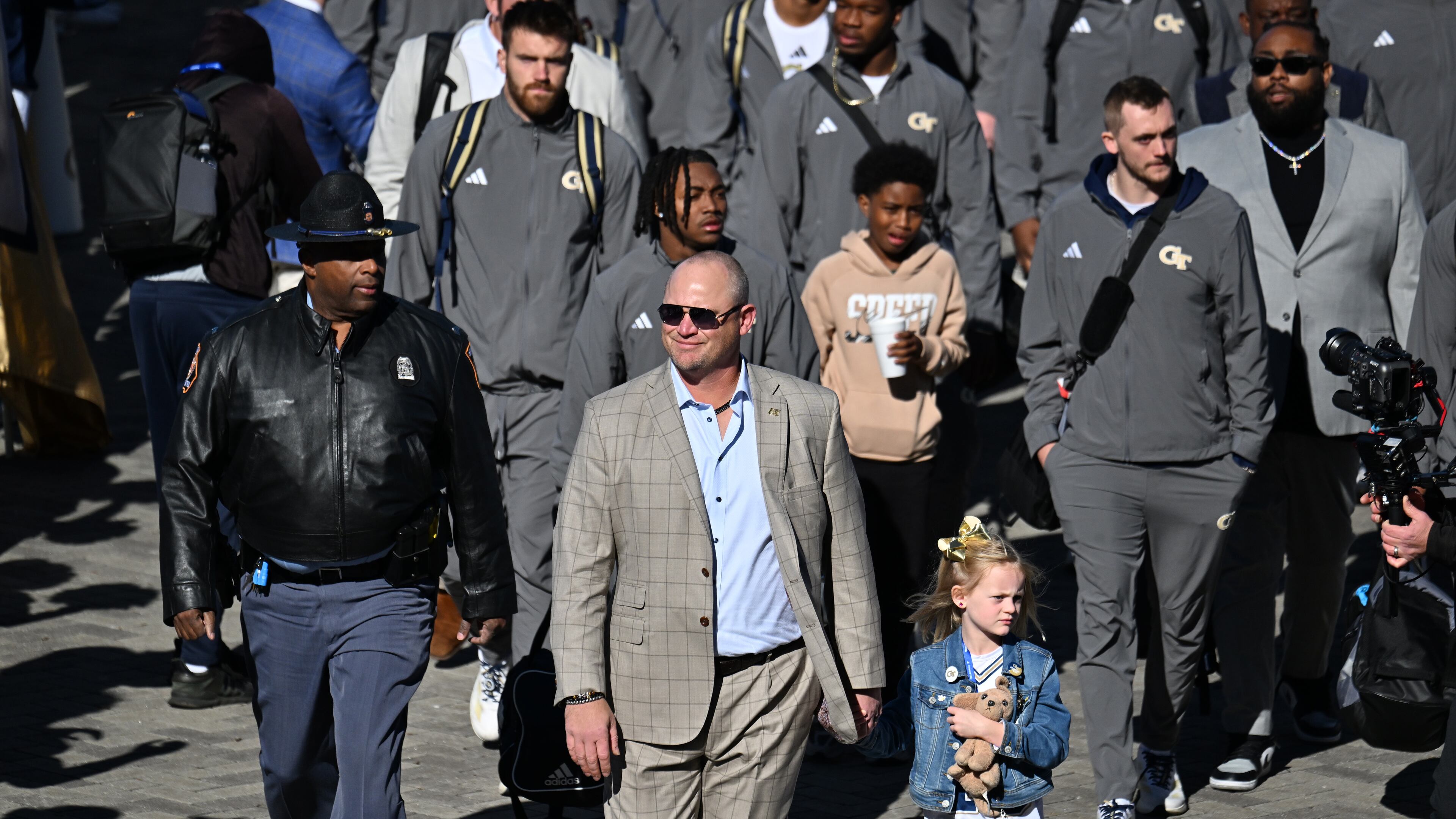 Georgia Tech head coach Brent Key with his daughter Harper arrives before the start of the Georgia Tech vs Georgia football game at Mercedes-Benz Stadium, Friday, November 28, 2025 in Atlanta. (Hyosub Shin / AJC)