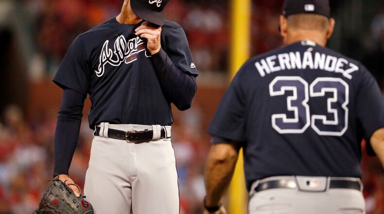 Braves starting pitcher Mike Foltynewicz, left, wipes his face as pitching coach Chuck Hernandez walks out to the mound during the second inning. (AP Photo/Jeff Roberson)
