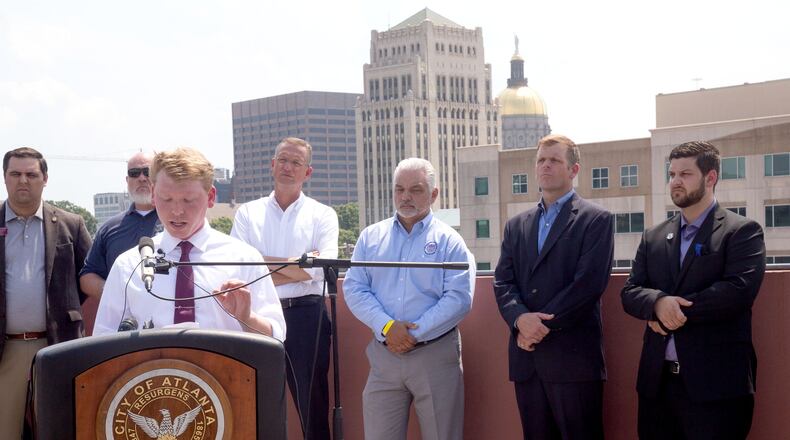 U.S. Rep Doug Collins (fourth from left) listens as Georgia state Rep. Matt Gurtler speaks to a group gathered on the top of the Atlanta police department headquarters parking deck Sunday, June 21. STEVE SCHAEFER FOR THE ATLANTA JOURNAL-CONSTITUTION